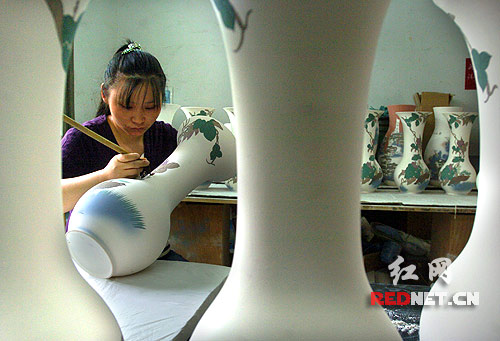醴陵醴泉窯藝的工人正在描繪釉下彩瓷瓶,陶瓷生產(chǎn)創(chuàng)造的價(jià)值約占醴陵國(guó)民生產(chǎn)總值的四成。